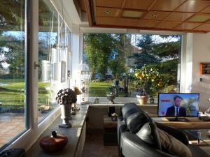 a room with a large window with a couch and a monitor at Bungalow Am Bahndamm 22 in Zingst