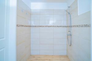 a bathroom with a shower with white tiles at Schleiblick App 15 - barrierearm in Karschau