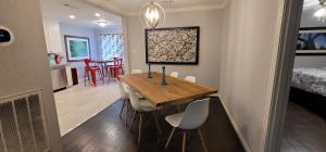 a dining room with a wooden table and chairs at The Harby Street House - Close to U of H, Stadiums, Downtown, Med Center in Houston