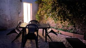 Una mesa y sillas en una habitación con ventana. en Bienvenue chez vous "appartement classé 2 étoiles en RDC avec espace extérieur et parking", en Dole