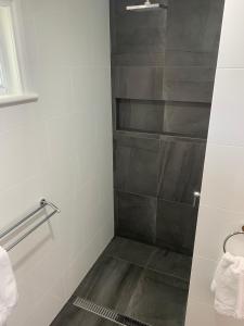 une salle de bain avec douche aux carreaux gris dans l'établissement Robe Nampara Cottages, à Robe