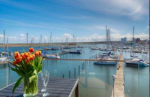 a vase of flowers on a table with a marina at Ostsee - Appartement Nr 99 "Ostseepanorama" im Strand Resort in Heiligenhafen
