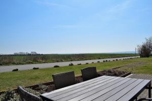 una mesa de madera y sillas con vistas a la carretera en Fehmarnstrand 78 RH 6, en Staberdorf