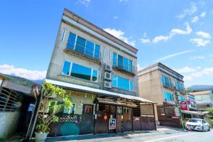 a tall building with blue windows on a street at Sunny Homestay in Jian