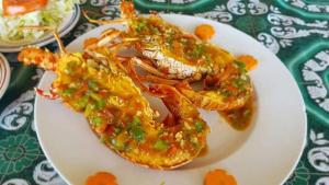 a plate of food with shrimp covered in sauce at Cabañas Tubasenika in Ailigandí