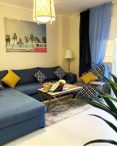 الشاطئ الازرق - الواحة في King Abdullah Economic City: غرفة معيشة مع أريكة زرقاء وطاولة