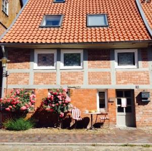 uma casa com um telhado laranja e uma mesa e cadeiras em DAS TRAUFENHAUS AM WALL - Urlaub im Denkmal em Boizenburg