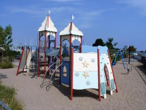um parque infantil com uma estrutura de brincar na areia em ancora Marina Haus 2 Nr 08, Typ 1 em Neustadt in Holstein