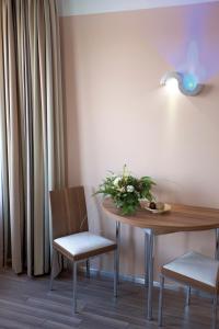 uma mesa e duas cadeiras e uma mesa com flores em ancora Marina Haus 2 Nr 08, Typ 1 em Neustadt in Holstein