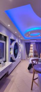 Florenza Khamsin Red Sea Residence في الغردقة: غرفة معيشة ذات سقف أزرق وتلفزيون