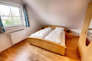 a bedroom with a wooden bed with a window at Loca in Zingst