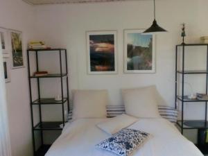 a bedroom with a white bed with two shelves at Ostseebrise 2 in Zingst