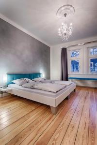 une chambre avec un grand lit et un lustre dans l'établissement "Villa Anker" 1 Etage - rechts, à Fehmarn