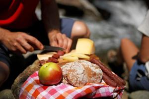 een persoon snijdt kaas en appels op een tafel bij Fewo Dreiraum im Haus Götsch 3 in Parcines