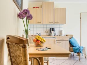 青斯特的住宿－App Am Paalen 18，厨房配有一张桌子,放着一碗水果和鲜花