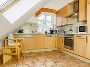 a kitchen with wooden cabinets and a window at Birkenstraße 7 Whg 6 in Zingst