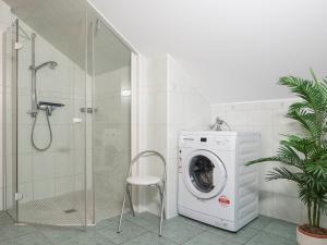 a bathroom with a washing machine and a shower at Birkenstraße 7 Whg 6 in Zingst