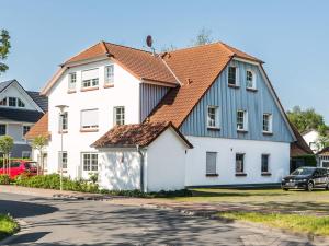 a large white house with an orange roof at Birkenstraße 7 Whg 6 in Zingst