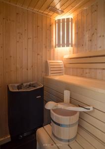 a wooden sauna with a toilet and a window at Ostsee - Reetdachhaus Nr 7 "Haddock" im Strand Resort in Heiligenhafen