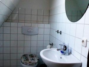 ein Badezimmer mit einem Waschbecken, einem Spiegel und einem WC in der Unterkunft Ostsseeferienoase Steilküste in Klütz