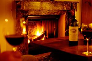 a bottle of wine sitting on a table with a fireplace at Ferienwohnung 7 mit Wasserblick, Balkon 2 Pers in Neuenkirchen
