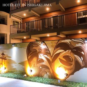 a building with a mural on the side of it at HOTEL FIT IN ISHIGAKIJIMA 新築2021年4月OPEN セキュリティ万全 セルフチェックイン -SEVEN Hotels and Resorts- in Ishigaki Island