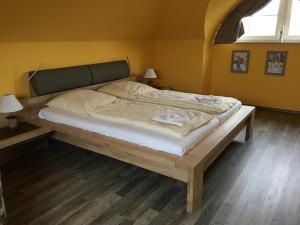 duże łóżko w pokoju z żółtymi ścianami w obiekcie Kapitän ParowWindjammer FW 11 w Zingst