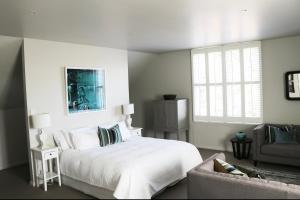 a white bedroom with a bed and a couch at Briarwood in Greytown