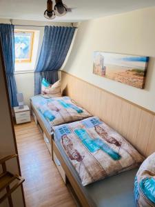 a bedroom with two beds and a picture on the wall at Hafenkiek 39 in Ostseebad Karlshagen