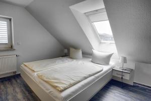 ツィングストにあるAltes Wasserwerk, App 3の窓付きの客室の白いベッド1台