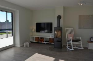 a living room with a fireplace and a flat screen tv at Småland in Kronsgaard