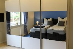 1 dormitorio con 2 camas y espejo en Ferienwohnung Zur Weinrebe, en Ebstorf