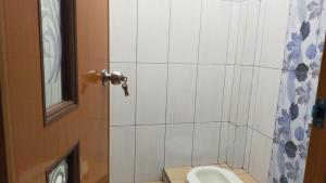 a bathroom with a toilet and a shower stall at Aqsa Guest House Ciamis Syariah in Ciamis