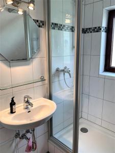 a bathroom with a sink and a shower at Haus Uschi - Ferienwohnung in Cismar