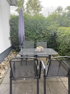 uma mesa com duas cadeiras e um guarda-sol em Kreutzmann Ferienwohnung für einen erholsamen Urlaub in ruhiger, zentraler Lage em Heiligenhafen