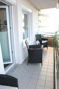 een patio met stoelen en tafels op een balkon bij "Cala Grömitz - Haus Tanneck" in Grömitz