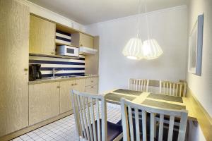 a kitchen with a table and chairs and a microwave at Am Kurhaus 211 PP 66 in Zingst