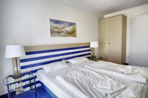 a bedroom with a bed with a blue and white stripes at Am Kurhaus 211 PP 66 in Zingst