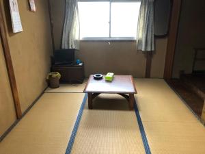 a room with a table on the floor with a window at 竜ケ崎駅そばの森田屋旅館 in Ryūgasaki