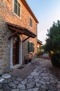 a brick building with a door and a stone walkway at CASA LORY Poggio Murella in Poggio Murella