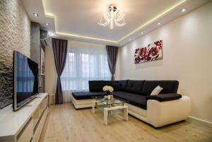 a living room with a couch and a tv at Apartman MDB LUX in Subotica