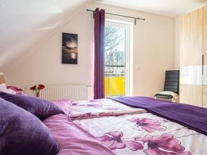 a bedroom with a bed with purple sheets and a window at Wiesenstraße 2 Whg 2 in Zingst