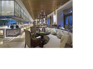 a restaurant with couches and a tables and chairs at Wanda Vista Tianjin in Tianjin