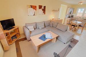 uma sala de estar com um sofá e uma mesa em Am Deich 16 em Zingst