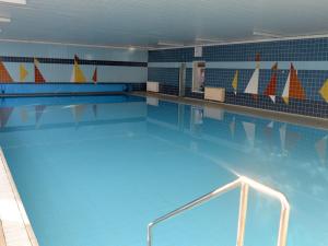 - une grande piscine avec de l'eau bleue et des voiliers sur le mur dans l'établissement Fewo 91 WHG A 12 in Burhave, à Burhave