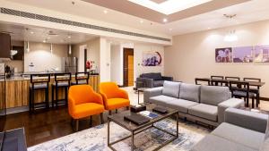 a living room with a couch and chairs and a kitchen at City Premiere Hotel Apartments - Dubai in Dubai
