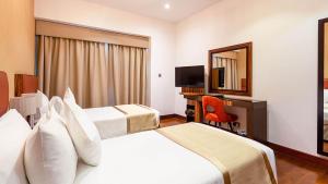 a hotel room with two beds and a mirror at City Premiere Hotel Apartments - Dubai in Dubai