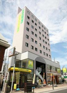 ein großes Gebäude in einer Stadtstraße mit einem Gebäude in der Unterkunft Hotel Select Inn Nagano in Nagano