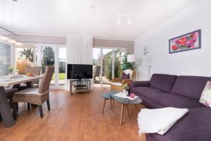 グレーミッツにあるM5 Bungalow - Apartmenthaus Marienburger Str 4 - FERIENDOMIZIL HOLLICHの紫色のソファとテーブル付きのリビングルーム