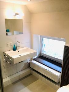 a bathroom with a sink and a window at DAS TRAUFENHAUS AM WALL - Urlaub im Denkmal in Boizenburg